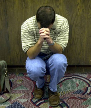 stranded traveler praying at airport