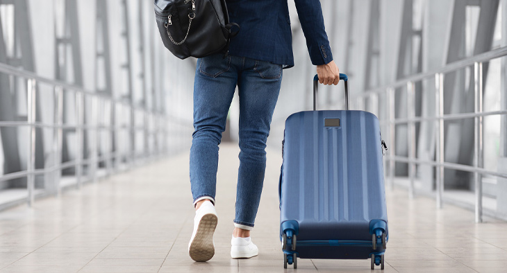 traveler walking through airport with a suitcase